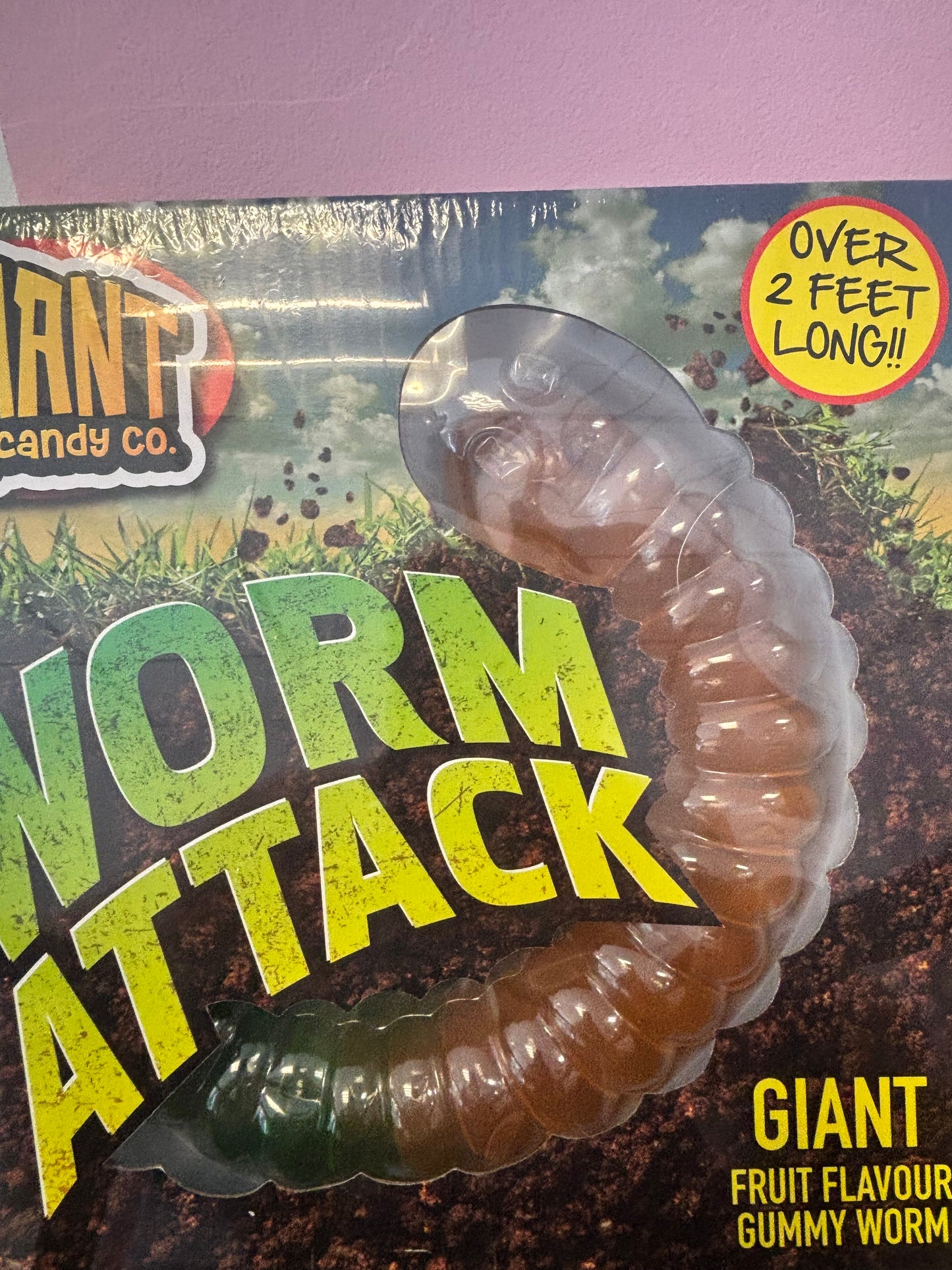 Gummy worm in packaging with 'Worm Attack' branding and text about size and flavor.